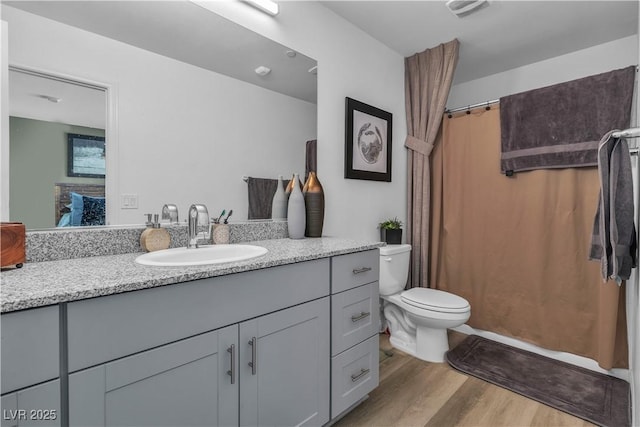 bathroom with visible vents, vanity, toilet, and wood finished floors