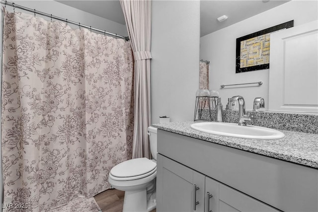 bathroom featuring vanity, toilet, and wood finished floors