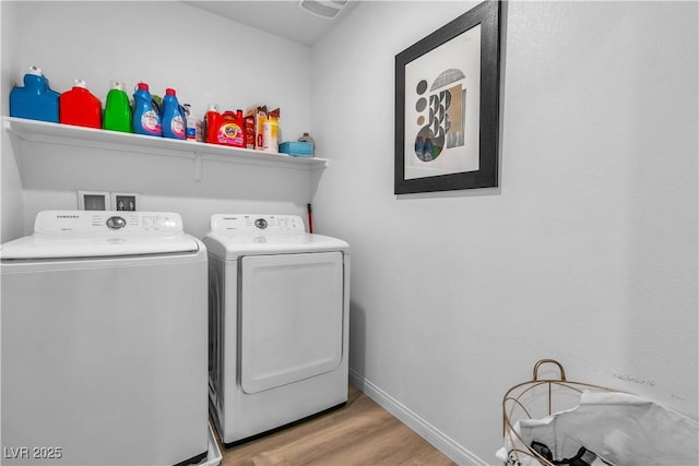 laundry room featuring wood finished floors, laundry area, baseboards, and separate washer and dryer