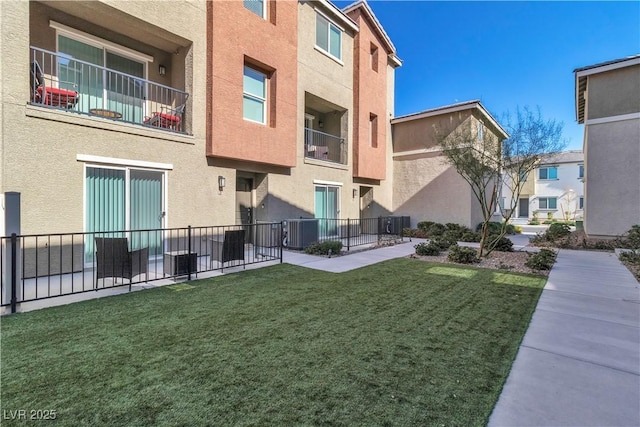 view of community featuring a yard and fence