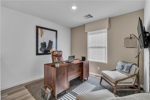 office with baseboards, visible vents, and wood finished floors