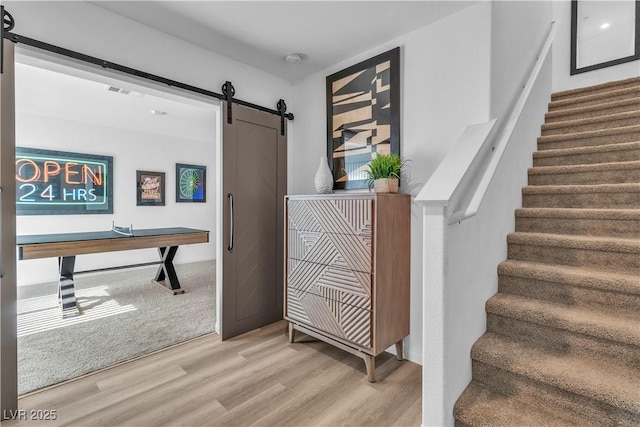 stairway with wood finished floors and a barn door