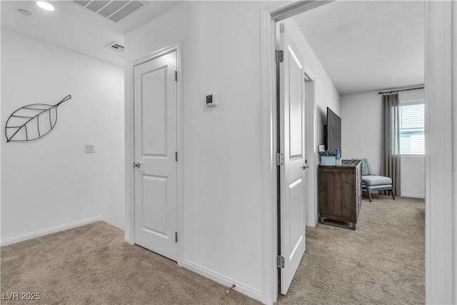 hallway with carpet flooring, visible vents, and baseboards