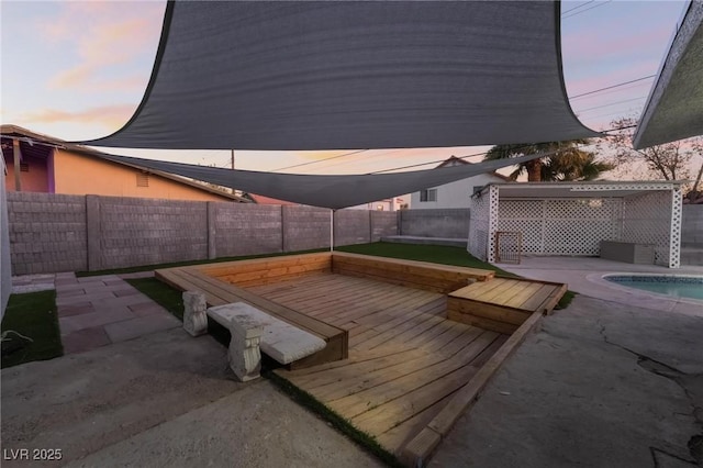 patio terrace at dusk featuring a swimming pool side deck