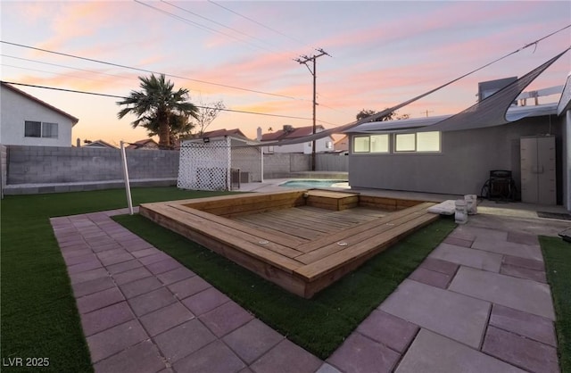 patio terrace at dusk featuring a pool side deck