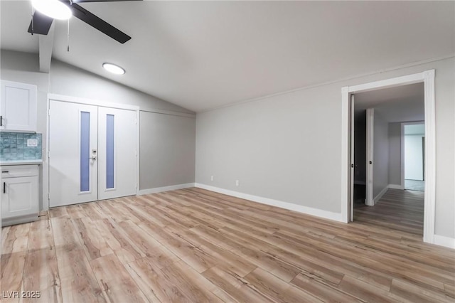 unfurnished living room with ceiling fan, lofted ceiling, and light hardwood / wood-style floors