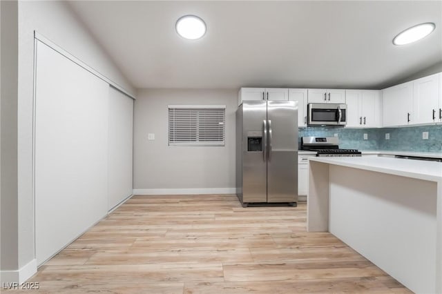 kitchen with white cabinetry, stainless steel appliances, tasteful backsplash, and light hardwood / wood-style flooring