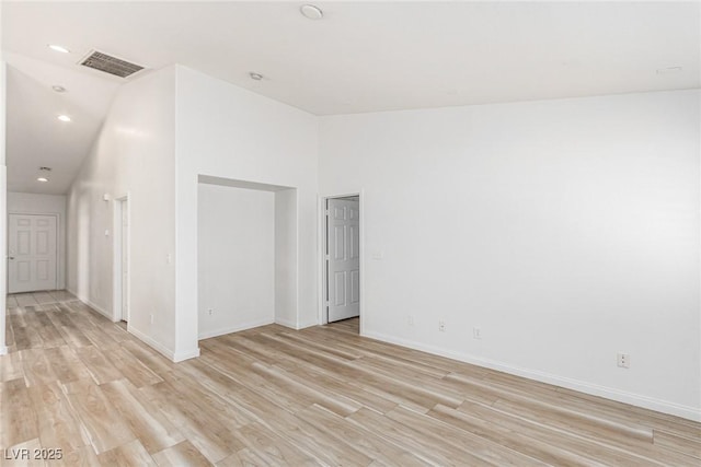 unfurnished room featuring high vaulted ceiling and light hardwood / wood-style floors