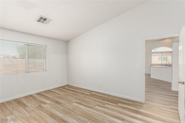 spare room with sink and light wood-type flooring