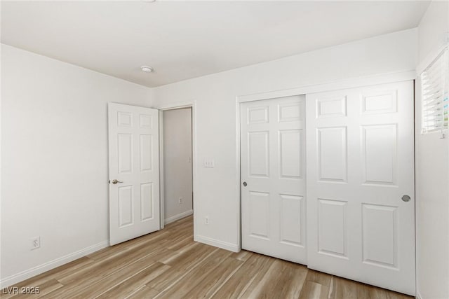 unfurnished bedroom featuring light hardwood / wood-style floors and a closet