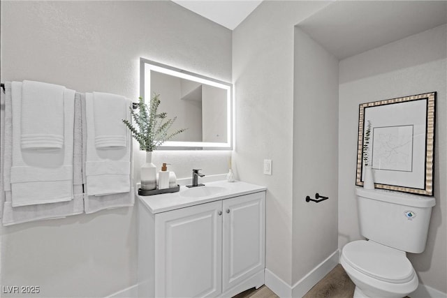 bathroom featuring vanity, toilet, and hardwood / wood-style floors