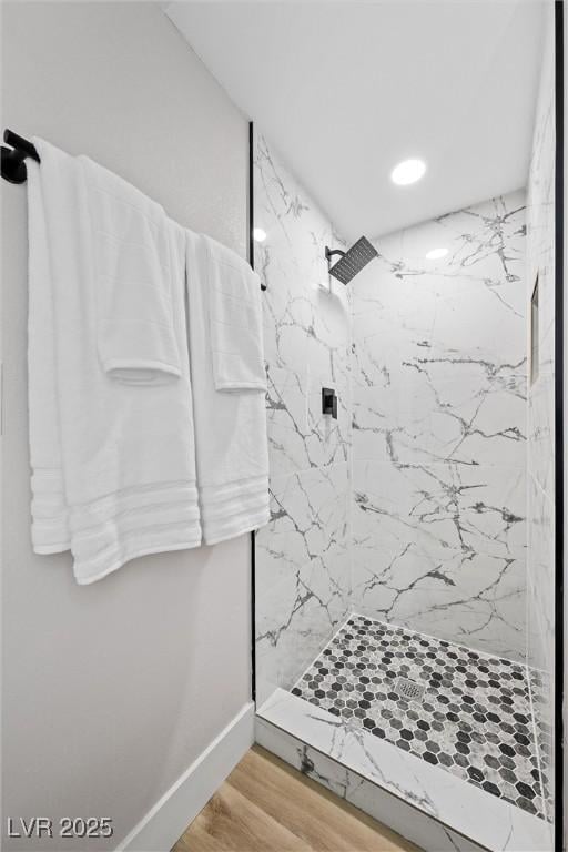 bathroom featuring hardwood / wood-style flooring and tiled shower