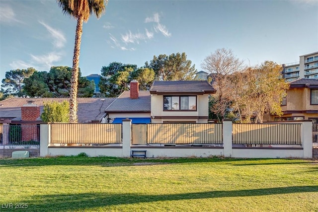 view of front of house with a front lawn, a chimney, fence, and stucco siding