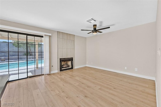 unfurnished living room with a fireplace, light hardwood / wood-style floors, and ceiling fan