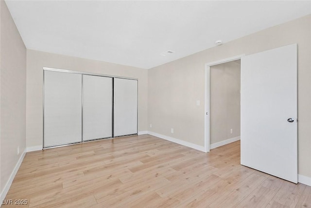 unfurnished bedroom with light hardwood / wood-style floors and a closet