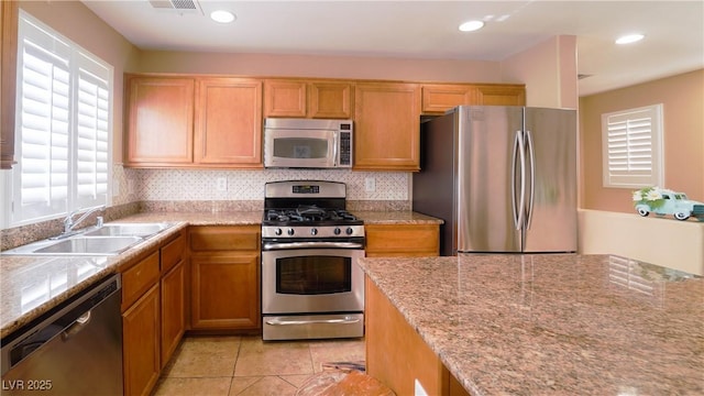 kitchen with sink, backsplash, stainless steel appliances, and light tile patterned floors