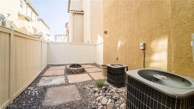 view of patio with central AC unit and a fire pit