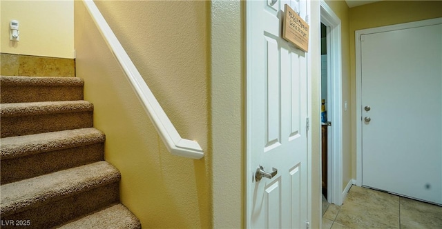 staircase featuring tile patterned flooring