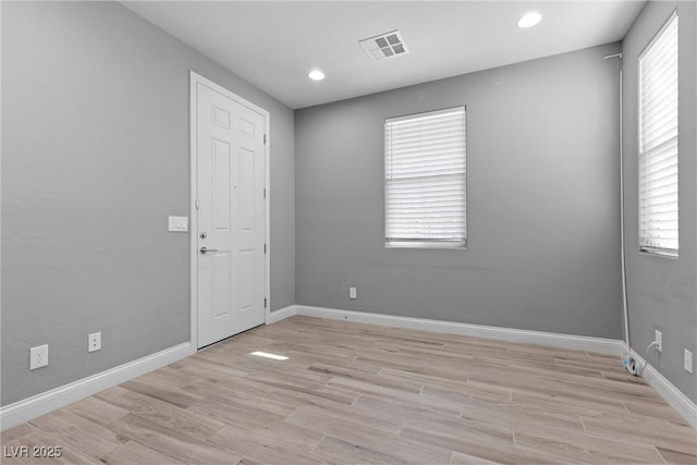 spare room featuring a wealth of natural light and light hardwood / wood-style floors