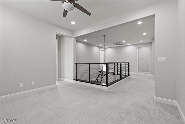 unfurnished room with light colored carpet and ceiling fan