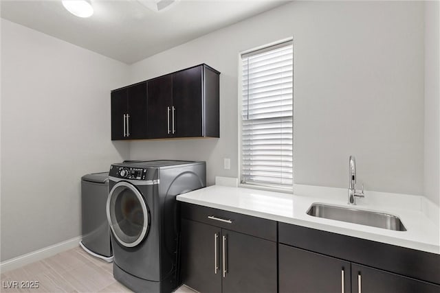 washroom featuring cabinets, washing machine and dryer, and sink