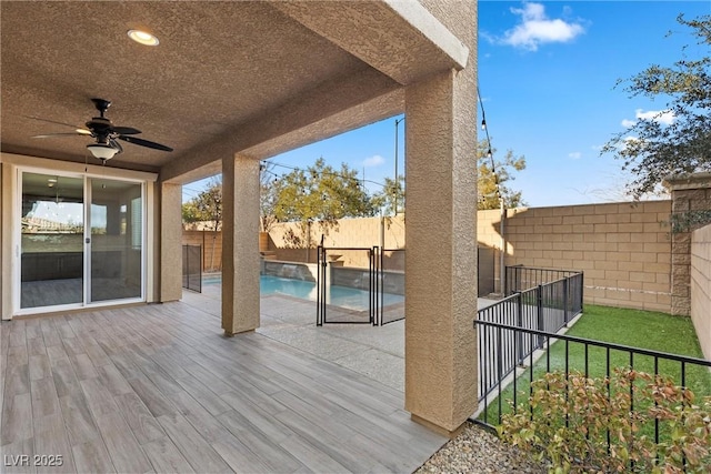 exterior space featuring ceiling fan and a fenced in pool