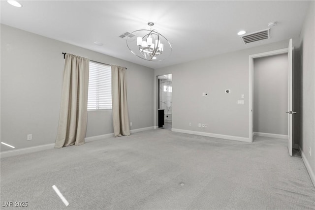 carpeted empty room featuring a notable chandelier