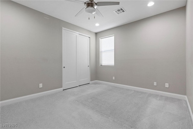 unfurnished bedroom featuring light colored carpet, a closet, and ceiling fan