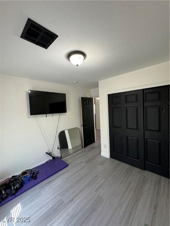 unfurnished office with a textured ceiling and light wood-type flooring