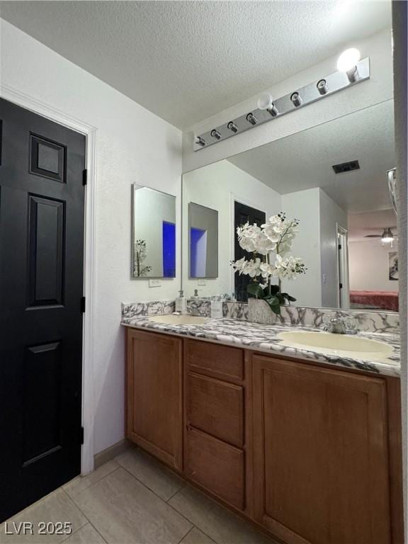 bathroom featuring vanity, tile patterned floors, and a textured ceiling