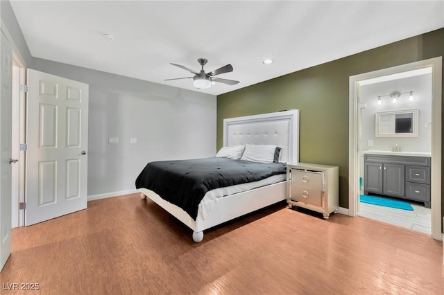 bedroom featuring ensuite bathroom, ceiling fan, and light hardwood / wood-style flooring