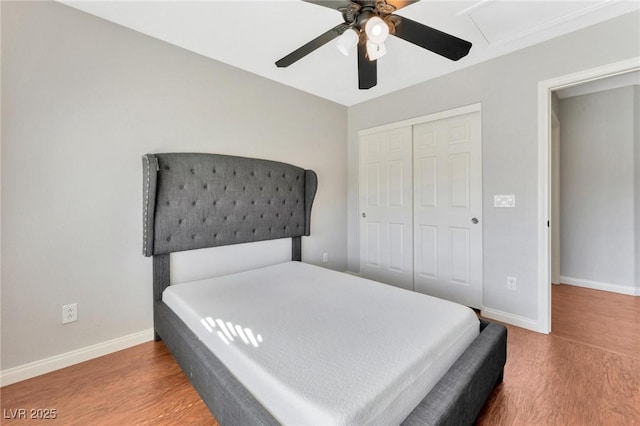 bedroom with hardwood / wood-style floors, ceiling fan, and a closet