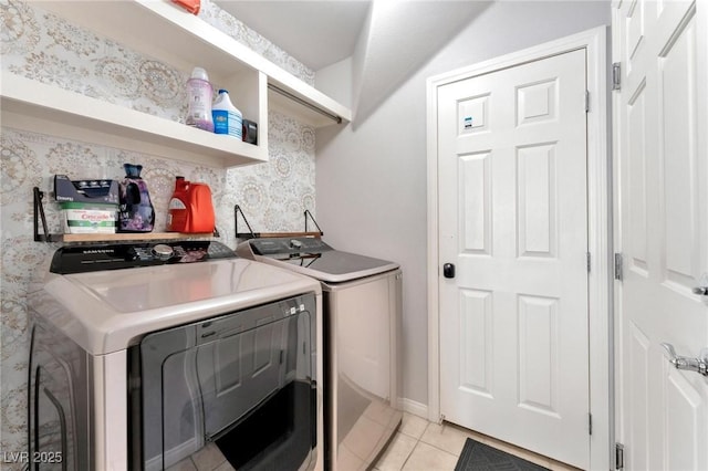 laundry area with washer and dryer and light tile patterned floors