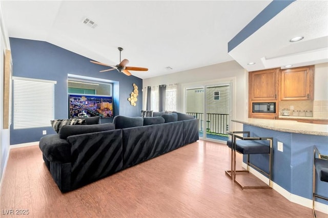 living room featuring ceiling fan, lofted ceiling, and hardwood / wood-style floors