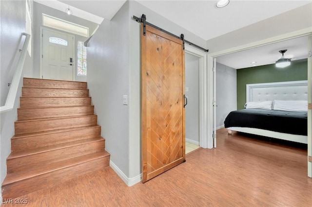 stairs with hardwood / wood-style floors and a barn door