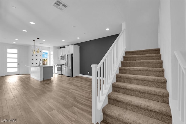 stairway featuring hardwood / wood-style flooring and sink