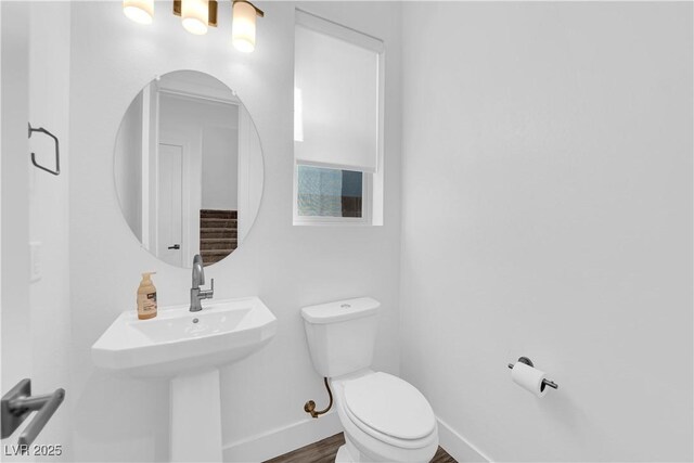 bathroom with toilet and hardwood / wood-style floors