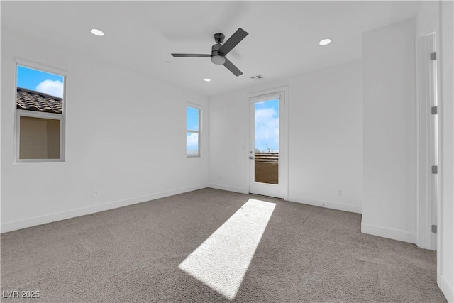 spare room with ceiling fan and light colored carpet