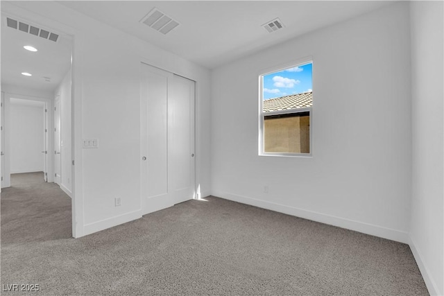 unfurnished bedroom featuring carpet flooring and a closet