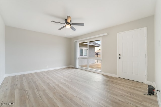 spare room featuring ceiling fan, light wood-style flooring, and baseboards