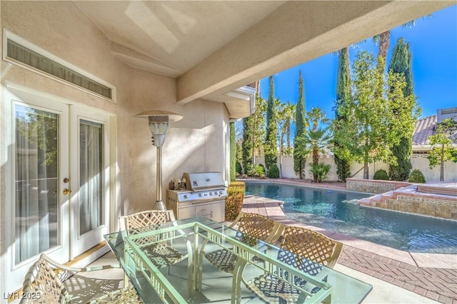 view of pool featuring pool water feature, grilling area, and a patio area