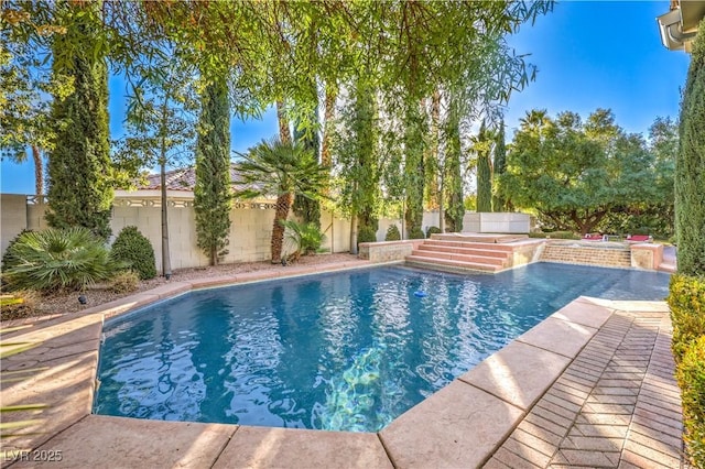 view of swimming pool featuring a hot tub