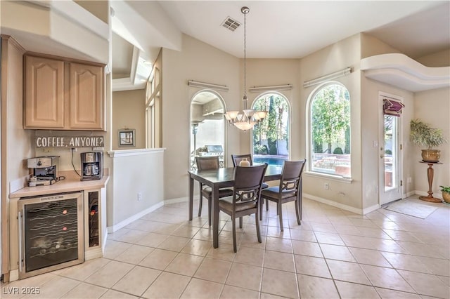 dining area with an inviting chandelier, beverage cooler, and light tile patterned flooring