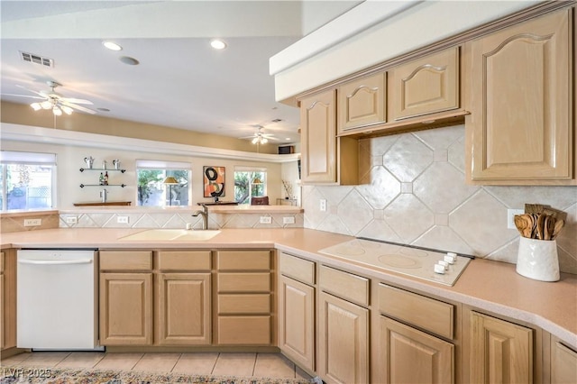 kitchen with white appliances, light brown cabinetry, kitchen peninsula, and a wealth of natural light