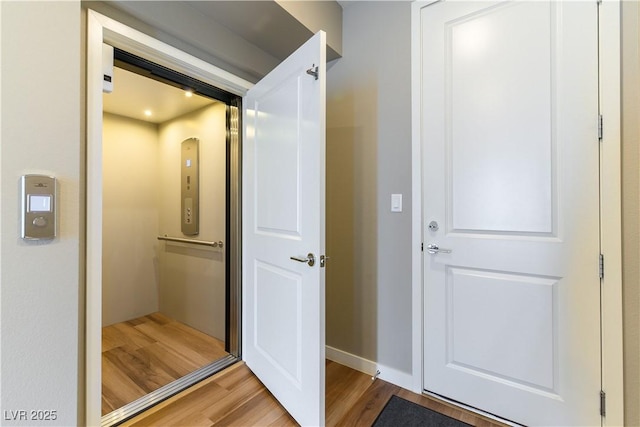 interior space with elevator and hardwood / wood-style floors