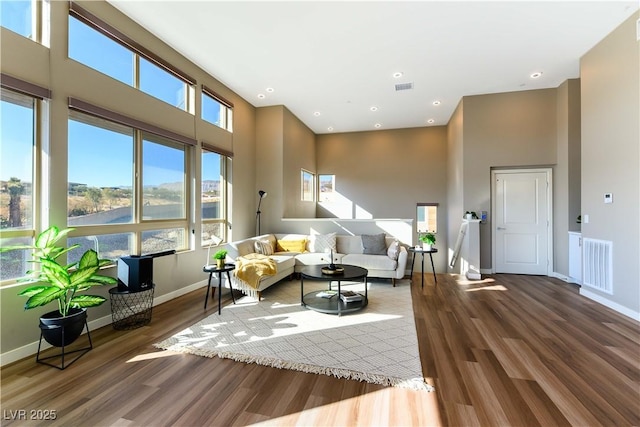 living room with hardwood / wood-style floors and a high ceiling