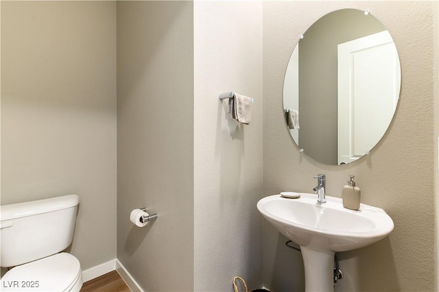 bathroom with hardwood / wood-style floors and toilet