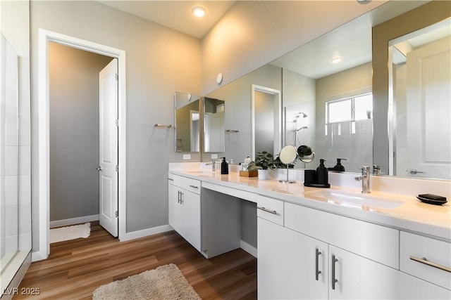 bathroom with hardwood / wood-style flooring, vanity, and walk in shower