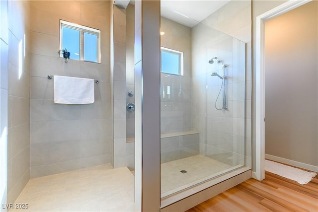 bathroom featuring hardwood / wood-style floors and tiled shower