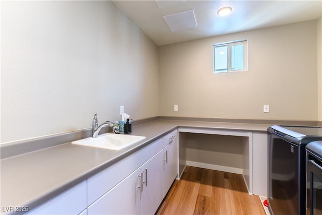 laundry room with separate washer and dryer, sink, cabinets, and light wood-type flooring